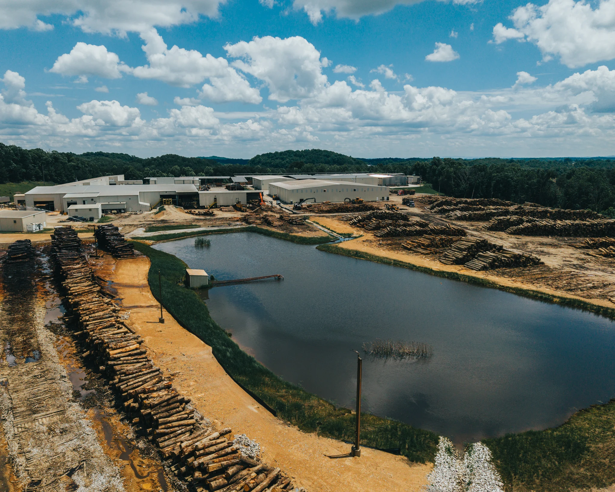 Aerial view of Kentucky Forest Products facility with log yards and settling pond