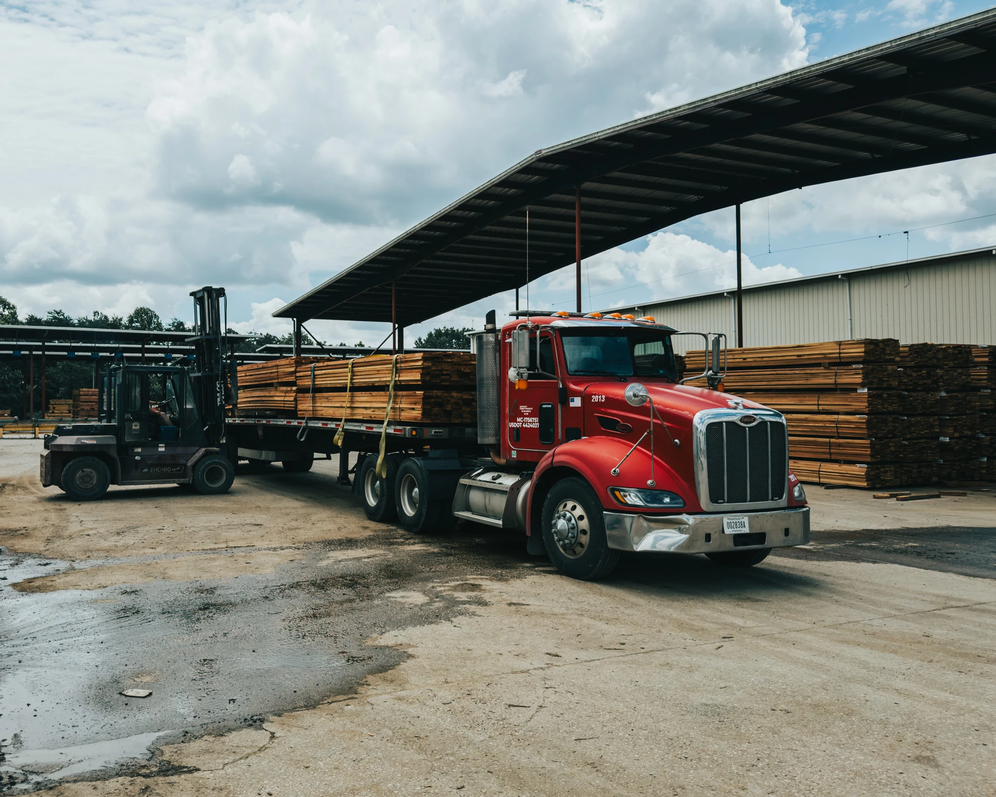 Forklift loading lumber onto a flatbed truck at the Kentucky Forest Products facility